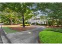 Classic home with green lawn, mature trees, and a long concrete driveway leading to the house at 3818 Sweet Bottom Dr, Duluth, GA 30096