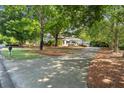 Home exterior with mature trees, manicured lawn, and a long concrete driveway at 3818 Sweet Bottom Dr, Duluth, GA 30096