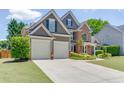 Spacious two-story home with a two-car garage, brick accents, and well-kept lawn at 1563 Country Wood Dr, Hoschton, GA 30548