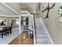Inviting foyer featuring hardwood floors, a staircase with iron railings, and decorative wall art at 1563 Country Wood Dr, Hoschton, GA 30548