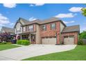 Charming two-story brick home with an attached three-car garage and fresh landscaping at 2470 Day Break Way, Dacula, GA 30019