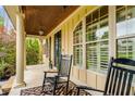 Inviting front porch with rocking chairs and wood ceiling at 374 Beaumont Farms Dr, Sharpsburg, GA 30277