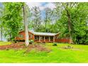 Lovely brick ranch-style home with green shutters surrounded by mature trees and a lush green lawn at 201 Smithstone Path, Fayetteville, GA 30214