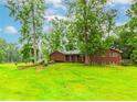 Traditional brick ranch-style home with green shutters nestled among mature trees, offering a serene setting at 201 Smithstone Path, Fayetteville, GA 30214