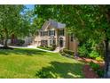 Traditional two-story home with lush front lawn, mature trees, and a two-car garage at 12350 Stevens Creek Dr, Alpharetta, GA 30005