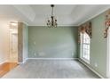 Dining room featuring neutral paint, carpet and crown molding, illuminated by a chandelier and natural light at 2682 Freemans Walk Path, Dacula, GA 30019