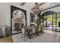 Elegant dining room with large mirror, wooden chandelier, seating for eight, and access to outdoor patio at 3888 Peachtree Dunwoody Rd, Atlanta, GA 30342