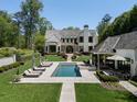 Beautiful backyard featuring a pool, spa, manicured lawn, and lounge seating, perfect for outdoor relaxation at 3888 Peachtree Dunwoody Rd, Atlanta, GA 30342