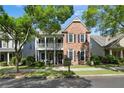 Attractive two-story brick home with a cozy double porch, framed by lush landscaping and mature trees at 655 Grove Manor Ct, Suwanee, GA 30024