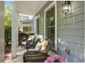 Inviting porch with comfortable wicker furniture, plants, and stylish address plaque at 655 Grove Manor Ct, Suwanee, GA 30024