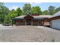 Charming home with a covered porch, stone accents, and a detached two-car garage with ample parking space at 200 Mcclure Dr, Cumming, GA 30028