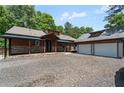 Charming home with a covered porch, stone accents, and a detached two-car garage with ample parking space at 200 Mcclure Dr, Cumming, GA 30028