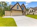 Beautiful home exterior features a multi-car garage, stone accents, and a well-manicured lawn at 208 Regester Way, Peachtree City, GA 30269
