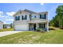 Inviting two-story home with a manicured lawn, integrated garage, and covered porch perfect for relaxing at 354 Jada Ln, Villa Rica, GA 30180