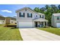 Two-story home featuring a two car garage, covered front porch, and an adjacent home on each side at 354 Jada Ln, Villa Rica, GA 30180