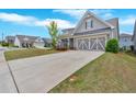 Charming home with grey siding, well-manicured lawn, and a long driveway to the attached two-car garage at 427 Bluffs View Ln, Canton, GA 30114