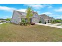 Wide shot of a grey one-story home with a well-manicured lawn and multi-car driveway at 427 Bluffs View Ln, Canton, GA 30114