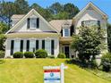Charming home featuring a well-manicured lawn, lush landscaping, and traditional architectural details at 1739 Praters Pt, Dacula, GA 30019
