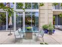 Charming patio featuring a glass table, seating, and views of the surrounding greenery and building at 1820 Peachtree St # 311, Atlanta, GA 30309