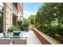 Cozy patio with lush greenery, a glass-top dining table, and comfortable seating at 1820 Peachtree St # 311, Atlanta, GA 30309