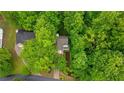 Aerial view of a home surrounded by lush green trees with a well manicured lawn, landscaping and long driveway at 3370 Ashton Dr, Suwanee, GA 30024