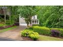 Inviting two-story home with a lush green lawn and a charming front porch, complemented by mature trees at 3370 Ashton Dr, Suwanee, GA 30024
