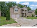 Charming two-story brick home featuring a double-door garage and welcoming front porch and upstairs balcony at 412 Live Oak Pass, Loganville, GA 30052