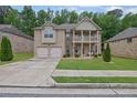 Charming two-story home boasts a double garage, landscaped yard, and a covered front porch at 412 Live Oak Pass, Loganville, GA 30052