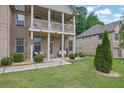 Inviting front porch and balcony adorned with decorative chairs and lush landscaping at 412 Live Oak Pass, Loganville, GA 30052