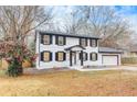 Charming two-story home with a white exterior, black shutters, and attached garage at 2328 Carnes Rd, Jonesboro, GA 30236