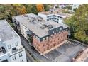 Wide aerial view of multi-story apartment building featuring attached balconies and a parking lot at 3649 Peachtree Ne Rd # 201, Atlanta, GA 30319