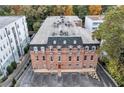 Aerial shot of brick apartment building featuring white windows and a gray roof and parking at 3649 Peachtree Ne Rd # 201, Atlanta, GA 30319