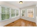 Cozy sunroom bathed in natural light, with multiple windows offering serene views. Hardwood flooring at 1266 Creekside Se Ter, Smyrna, GA 30082
