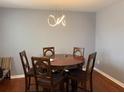Dining room features a wood table with chairs, modern light fixture, and hardwood floors at 4701 Flat Shoals Rd # 37E, Union City, GA 30291