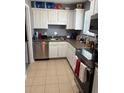 View of kitchen with white cabinets, stainless steel appliances, and tile floors at 4701 Flat Shoals Rd # 37E, Union City, GA 30291