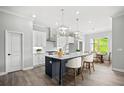 Modern kitchen featuring an island with seating, stainless steel appliances, and a dining area at 1101 Cooks Farm Way, Woodstock, GA 30189
