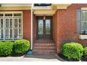 Close-up of elegant front door with decorative glass and brick surround, adding a touch of sophistication at 1477 Edenham Ln, Cumming, GA 30041