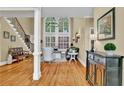 Bright and airy living room featuring hardwood floors, soaring windows, and elegant staircase at 1477 Edenham Ln, Cumming, GA 30041