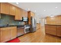 Spacious kitchen with stainless steel appliances, black countertops, wooden cabinets, and hardwood floors at 1728 N Holly Ne Ln, Atlanta, GA 30329