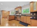 Kitchen features wooden cabinets, stainless steel appliances, black countertop, hardwood floors, and natural light at 1728 N Holly Ne Ln, Atlanta, GA 30329