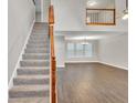 Open-concept living room featuring wood floors, a stairway, and lots of natural light from large windows at 3514 Willgrove Way, Duluth, GA 30096