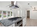 Open kitchen boasts a gas cooktop, granite countertops, and views of the living area with large windows at 705 Country Park Se Dr, Smyrna, GA 30080