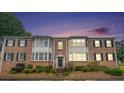 Charming brick townhouse with black shutters, trimmed windows and well-kept landscaping at dusk at 2349 Henderson Mill Ne Rd # 2, Atlanta, GA 30345