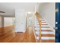 Bright entryway with hardwood floors, a staircase, and a white door leading to the living areas at 3055 Kennesaw Nw Dr, Kennesaw, GA 30152