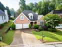 Inviting brick home with landscaped yard, two-car garage, and lush green surroundings at 3082 Monarch Pine Dr, Peachtree Corners, GA 30071