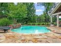 Inviting backyard pool featuring a waterfall, stone surround, and lush landscaping at 18 Starlight Dr, Cartersville, GA 30121