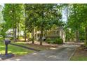 Two-story home with a long driveway and lush landscaping, set amongst mature trees at 944 Hardy Cir, Dallas, GA 30157