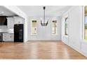 Bright dining room featuring hardwood floors, white trim, large windows, and a stylish chandelier above the dining area at 206 Regester Way, Peachtree City, GA 30269
