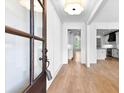 Elegant foyer with hardwood floors, white walls, a decorative light fixture, and a view into the modern kitchen at 206 Regester Way, Peachtree City, GA 30269
