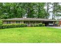 Charming one-story brick home featuring a lush lawn and a convenient attached carport at 3549 Dogwood Dr, Powder Springs, GA 30127